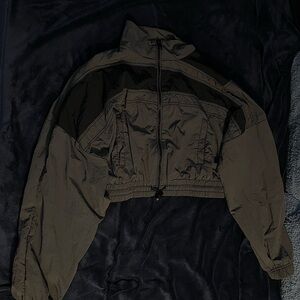 Dark gray zip up parachute jacket with black stripes.